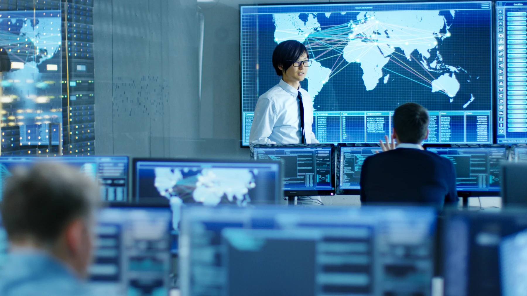 Computerzentrale mit mehreren Bildschirmarbeitsplätzen und einer großen Übersichtswand