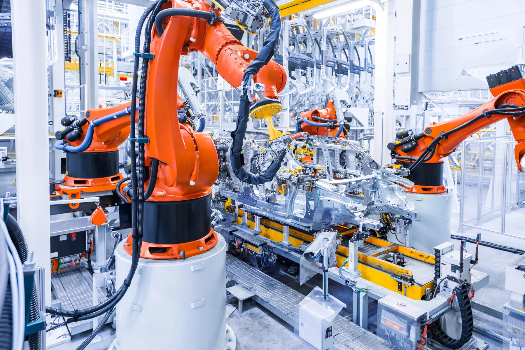 Industrielle Roboteranlage im Fahrzeugbau mit mehreren Roboterarmen und abgegrenzten Arbeitsbereichen