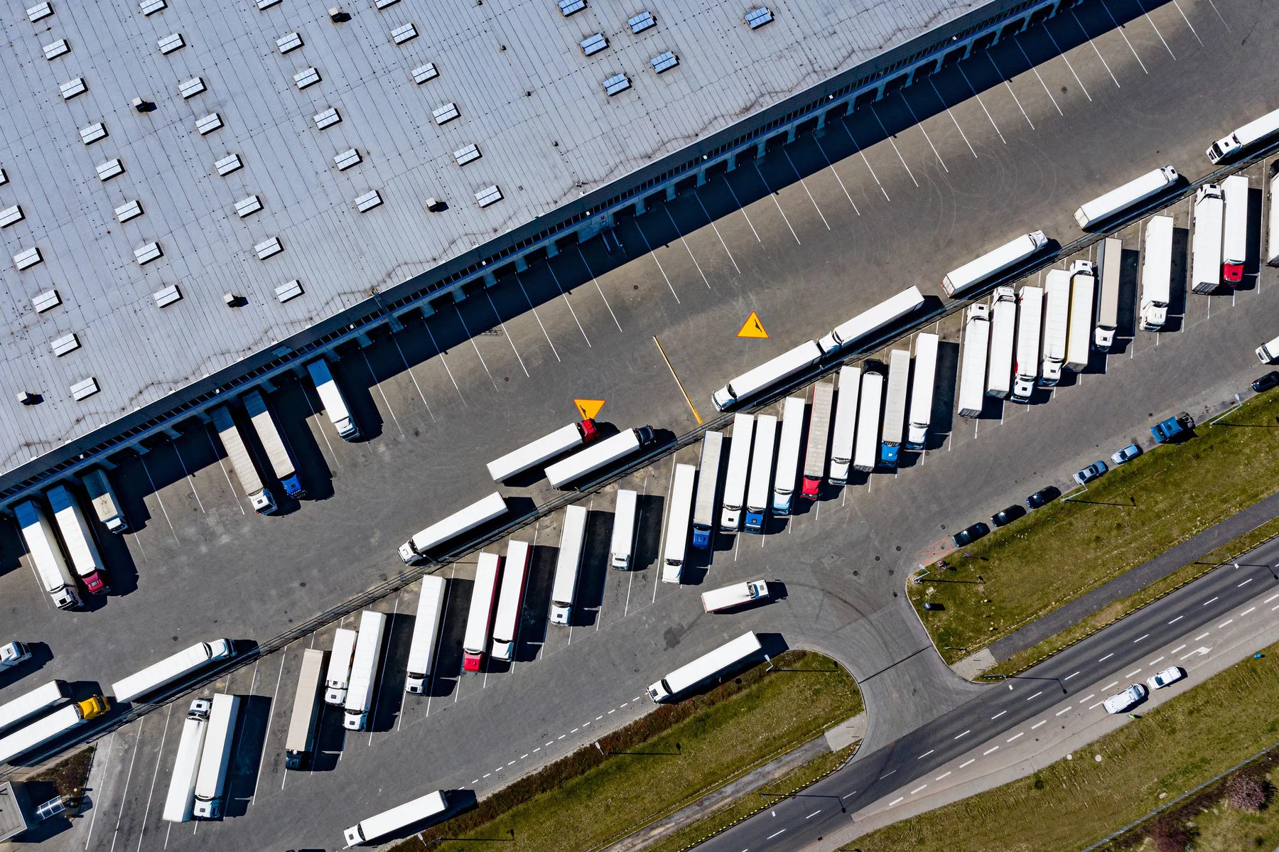 Luftaufnahme von Laderampen und Lkw an einem Logistikzentrum