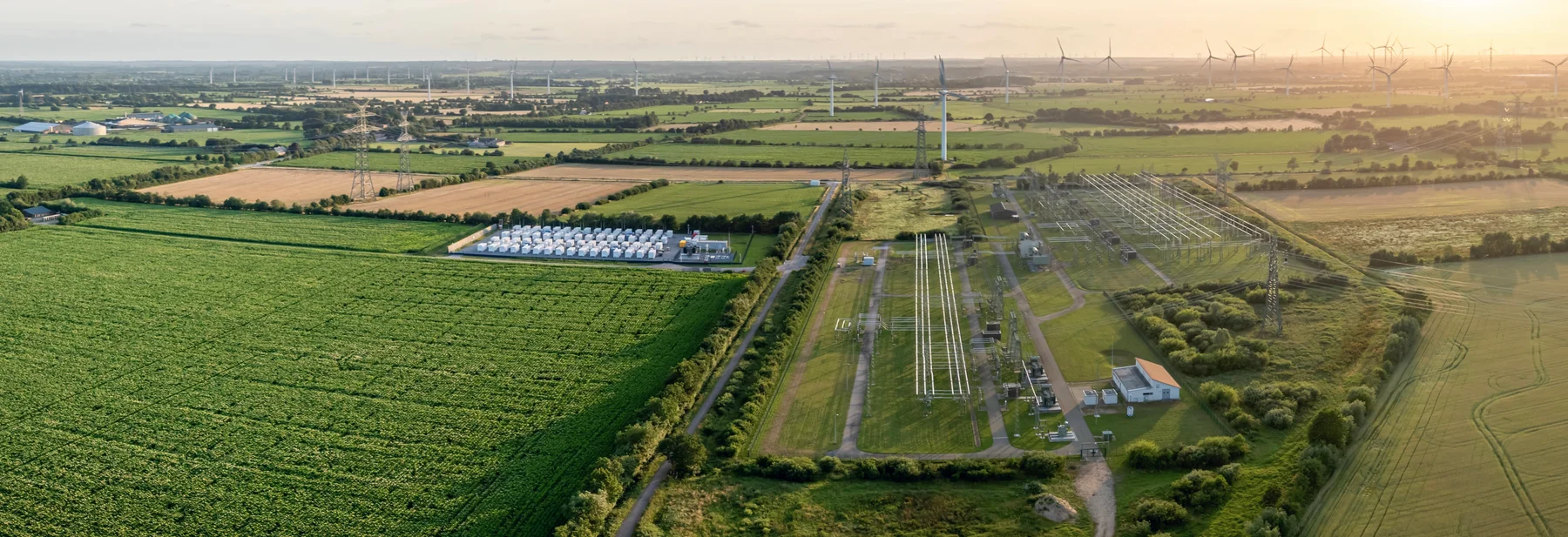 Luftaufnahme eines Batteriespeicherparks neben einem Umspannwerk in ländlicher Umgebung